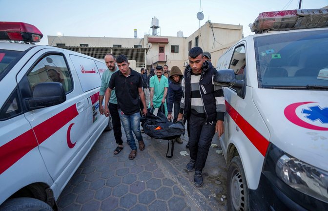 Palästinenser tragen die Leiche eines Mitarbeiters der World Central Kitchen im Al Aqsa Krankenhaus.<span class='image-autor'>Quelle: Unbekannt</span>