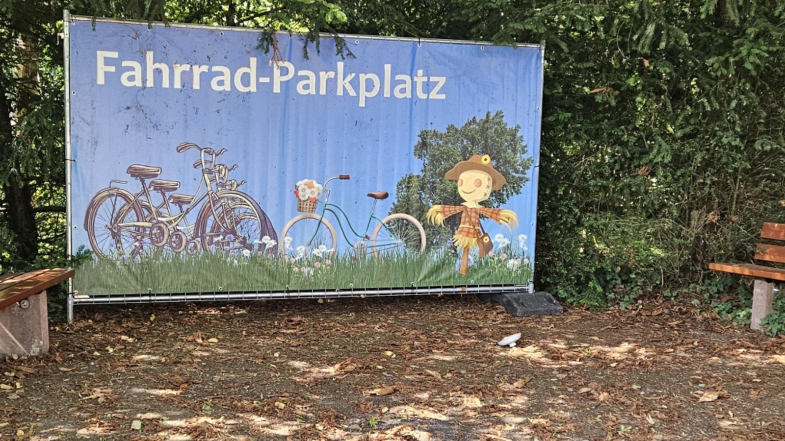 Gegenüber des Eingangs kann man im Schatten rasten. Rad parken geht auch.