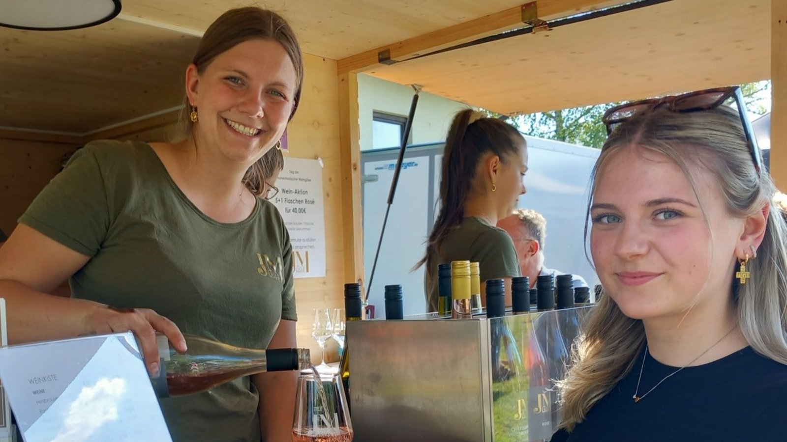Gute Stimmung bei bestem Sommerwetter: Die Jungwinzerin und Weinprinzessin Jule Mayr (links) schenkt ihre hauseigenen Weine auf der grünen Wiese aus. Fotos: Glemser