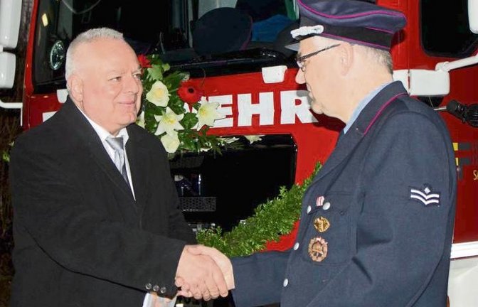 Bürgermeister Horst Fiedler (links) übergibt das neue Löschfahrzeug.  Foto: Friedrich