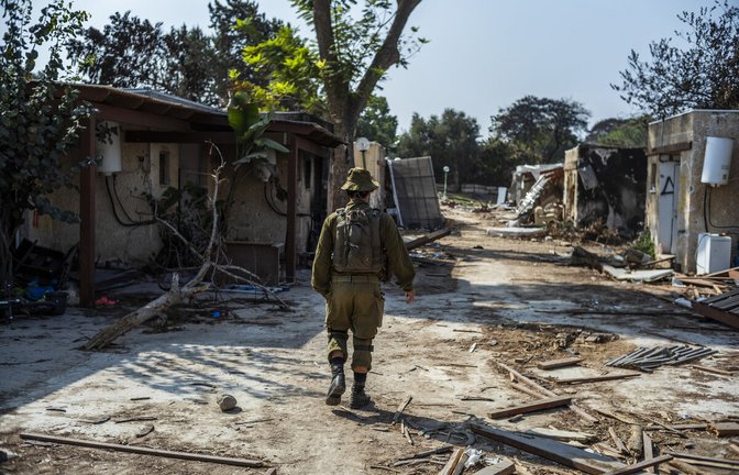 Ein israelischer Soldat geht an zerstörten Häusern im Kibbuz Kfar Aza vorbei. Der Kibbuz war im Oktober 2023 von Hamas-Terroristen angegriffen worden. Viele Bewohner wurden ermordet.<span class='image-autor'>Foto: dpa/Ilia Yefimovich</span>