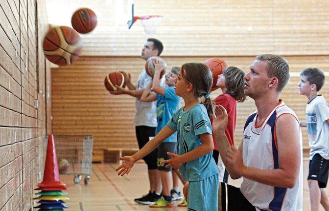Jonas Landenfeld übt mit den jungen Gästen der BSG Vaihingen/Sachsenheim Würfe. Gestern machte das Kinderferienprogramm der Stadt Vaihingen Station bei den Basketballern. Fotos: Küppers