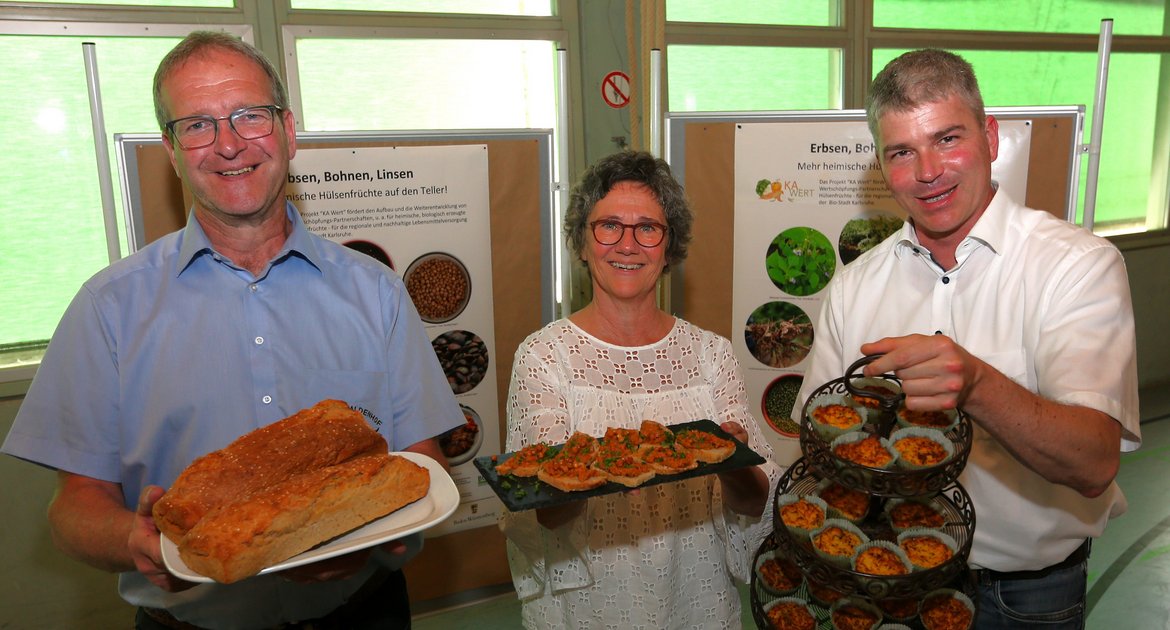 Wiernsheimer Proteinwerkstatt Projekt für Hülsenfrüchte WierPro, Wier-Pro, gefördert von Gemeinde und Bund, von links Landwirt Frank Bäuerle, Projektleiterin Sandra Schmidt und Bürgermeister Matthias Enz mit einigen der Erzeugnisse, die bei der Auftaktveranstaltung in der Kreuzbachhalle Iptingen verkostet werden können