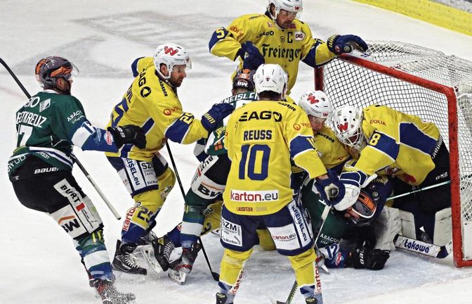Füchse-Goalie Mac Carruth (von rechts) ist bei einem Angriff von C.J. Stretch zwar im eigenen Tor, nicht aber die Hartgummischeibe. Foto: Baumann