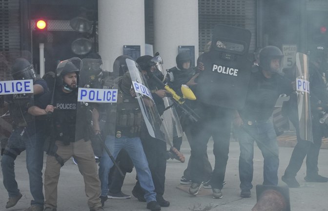 Polizeibeamte versammeln sich, während Tränengas die Luft füllt, während eines Protests, nachdem die Bundeseinwanderungsbehörden in Los Angeles eine Operation durchgeführt haben.<span class='image-autor'>Foto: AP/dpa/Jae C. Hong</span>