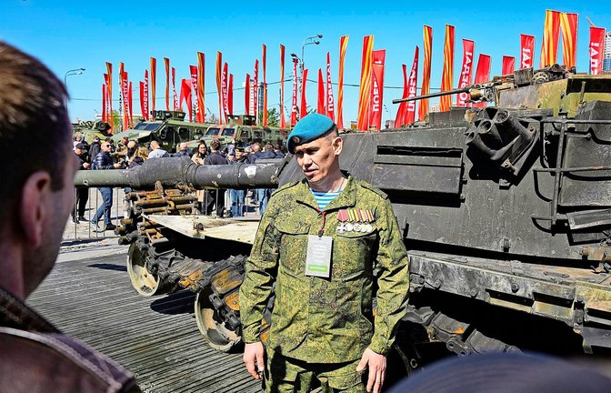Ausgestellte Kriegsbeute in Moskau: Ein russischer Offizier steht vor einem in den USA hergestellten M1-Abrams-Panzer, der  von russischen  Streitkräften aus der Ukraine mitgebracht wurde.<span class='image-autor'>Foto: dpa/Alexander Zemlianichenko</span>