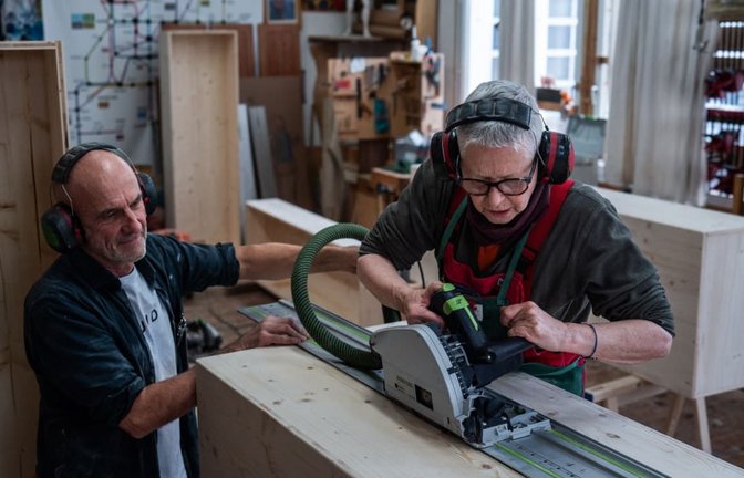 Angelika Paulus setzt die  Tauchsäge an. Der Freiburger Schreinermeister und Workshopleiter  Johannes Wittich behält die Sargbauerin im Blick.<span class='image-autor'>Dominic Nahr</span>