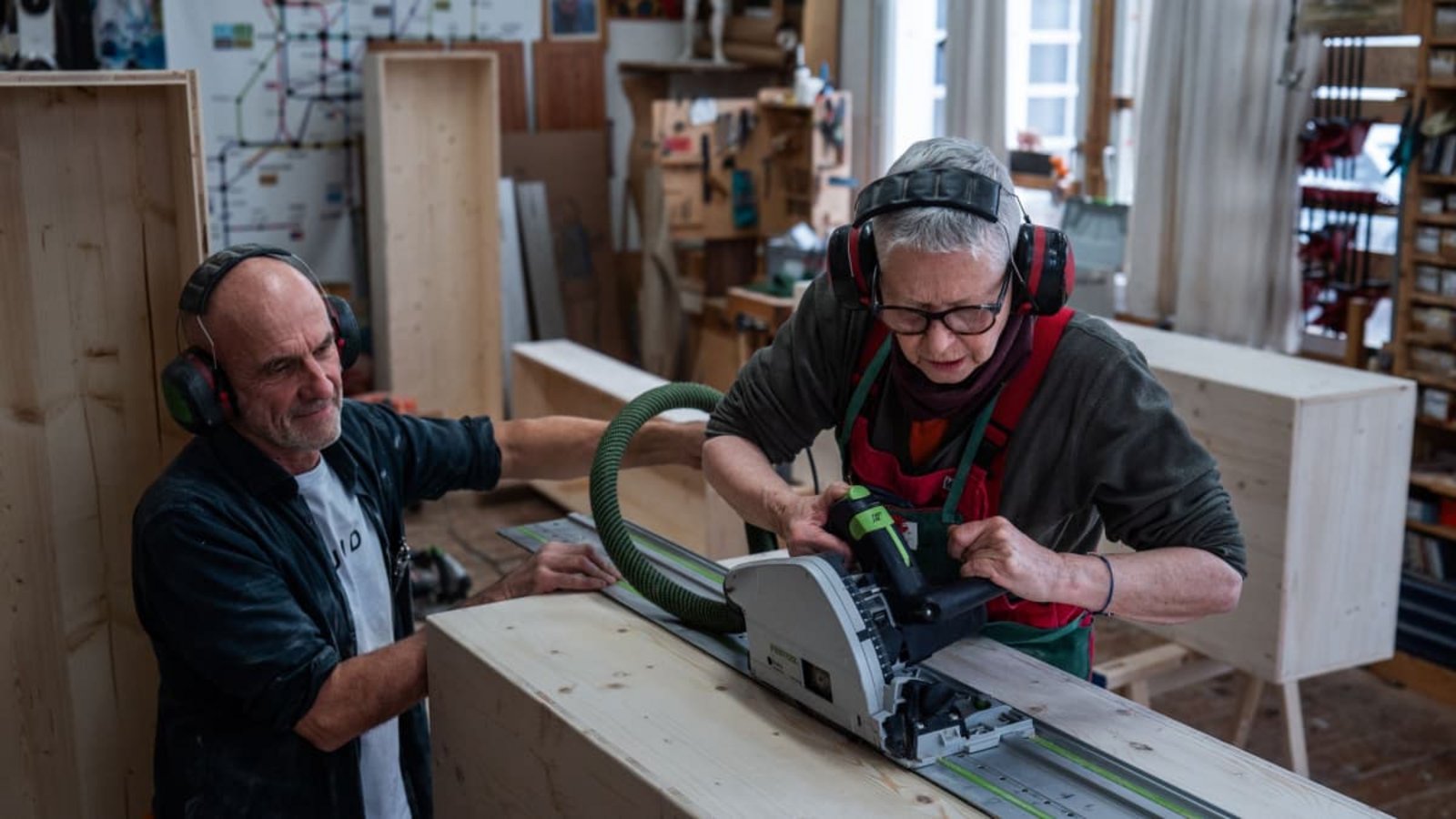 Angelika Paulus setzt die  Tauchsäge an. Der Freiburger Schreinermeister und Workshopleiter  Johannes Wittich behält die Sargbauerin im Blick.Dominic Nahr