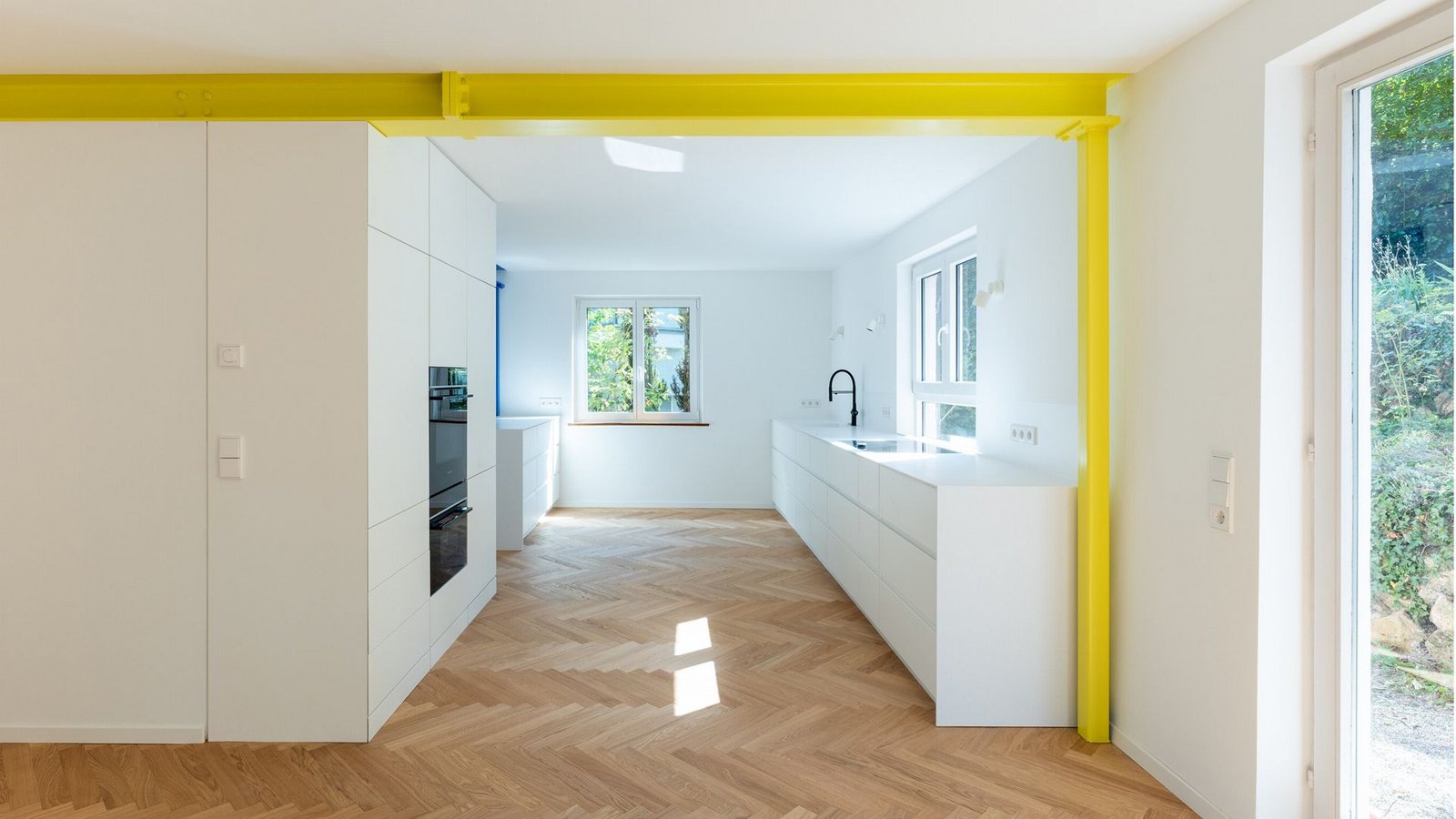 Hausumbau in Stuttgart: Ein schwefelgelber Stahlträger sorgt für eine gelungene Zonierung des offenen Grundrisses im Wohn- und Küchenbereich.Foto: Kai Loges