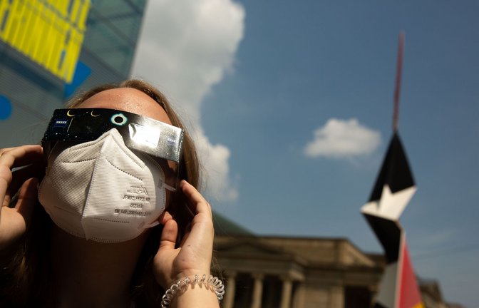 Zuletzt war am 10. Juni 2021 eine partielle Sonnenfinsternis zu beobachten: Eine junge Frau schaut auf dem Stuttgarter Schlossplatz durch eine Schutzbrille dem Himmelsspektakel zu.<span class='image-autor'>Foto: Lichtgut/Leif Piechowski</span>
