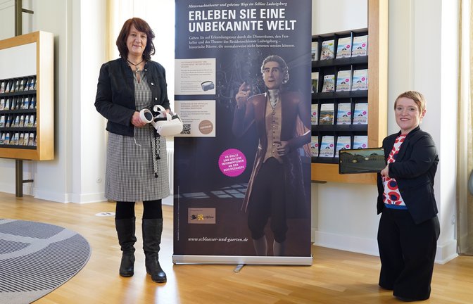 Finanzstaatssekretärin Gisela Splett (links) hat mit der Beauftragten der Landesregierung für die Belange von Menschen mit Behinderungen, Simone Fischer (rechts) , ein neues virtuelles Führungsangebot im Residenzschloss Ludwigsburg vorgestellt. Splett: „Die Staatlichen Schlösser und Gärten Baden-Württemberg entwickeln ihr digitales Angebot weiter. High-Tech trifft auf Jahrhunderte alte Geschichte und ermöglicht es so allen Menschen, am kulturellen Erbe des Landes noch besser teilzuhaben. Neue Techniken eröffnen neue Möglichkeiten. Und das kommt allen zugute, die sich für ein Monument wie Schloss Ludwigsburg interessieren.“ Fischer: „Barrierefreiheit schafft Zugänglichkeit, damit alle Menschen in den Genuss der vielfältigen Geschichte und Kultur unseres Landes kommen. Es ist erfreulich, dass wir in einer Zeit leben, die durch technische und digitale Möglichkeiten bessere Zugänge schaffen kann. Diese Techniken zu nutzen, von Beginn an barrierefrei einzusetzen und weiterzuentwickeln, ist eine große Chance für eine verbesserte Teilhabe aller Menschen in unserer Gesellschaft.“ Besucher können künftig mit Virtual Reality drei Räume im Schloss Ludwigsburg entdecken, die sonst nur eingeschränkt zugänglich sind. Dazu gehören die Dienertreppe, der Bühnenboden des Schlosstheaters und der Fasskeller, die nun auch interaktiv erlebbar sein werden. So soll auch für Menschen mit Assistenzbedarf ein umfassendes Besuchserlebnis und eine Teilhabe am kulturellen Erbe möglich werden. Mit dem neuen Angebot bietet Schloss Ludwigsburg somit einen erweiterten Zugang zum Kulturerbe. Die digitale Erschließung öffnet die Tore in den historischen Mauern und die Wege zu ihren Geheimnissen für alle.  <span class='image-autor'>Foto: p</span>