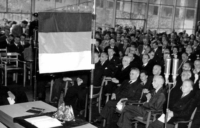 Das Grundgesetz auf dem Tisch unter der deutschen Fahne – 75 Jahre ist das nun her.<span class='image-autor'>Foto: dpa/dpa</span>