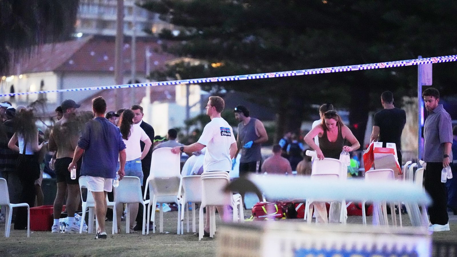Menschen und Rettungskräfte versammeln sich am Bondi Beach in Sydney, wo eine Festtagsveranstaltung stattfand und anschließend ein Zwischenfall gemeldet wurde.Foto: Mark Baker/AP/dpa