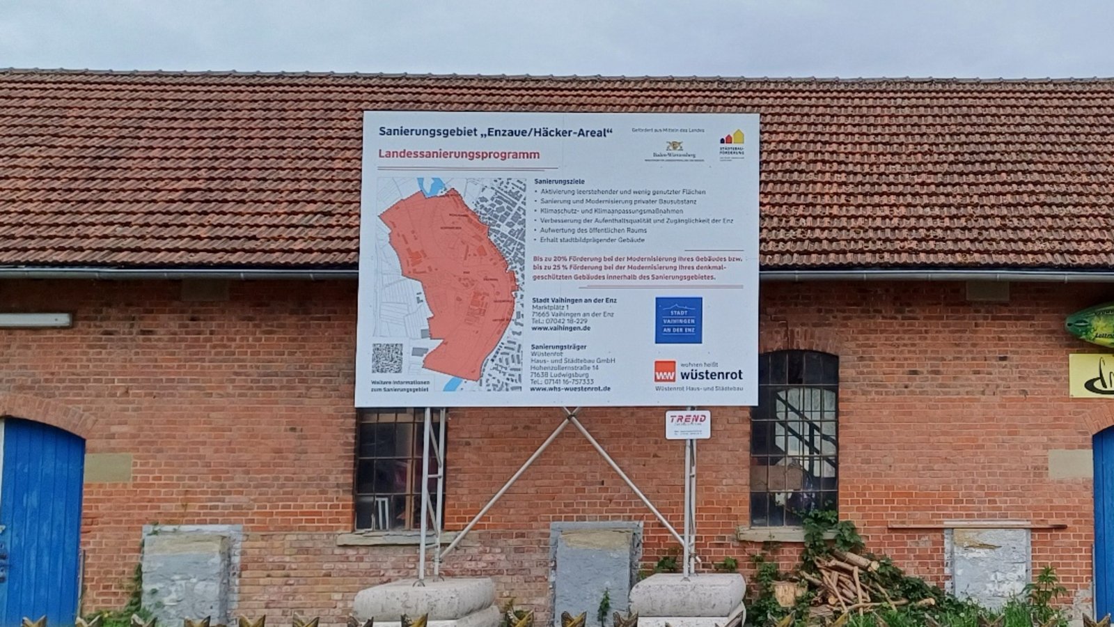 Mit einem großen Schild am Backsteingebäude in den Vaihinger Köpfwiesen wird seit ein paar Tagen auf das Sanierungsgebiet „Enzaue/Häcker-Areal“ hingewiesen. Foto: Rücker