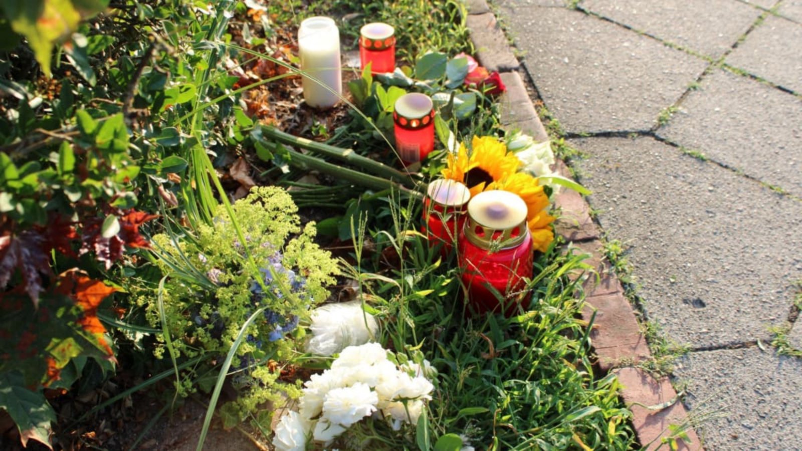 Blumen und Kerzen liegen nahe einem Gebäude einer Jugendeinrichtung in Stade. In der Einrichtung waren mehrere Menschen durch Schüsse gestorben.Kai Moorschlatt/dpa