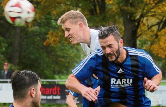 Enzweihingens Flamur Gjinovci (rechts) rechts köpft den Ball vor Sascha Streicher weg. Foto: Nachreiner