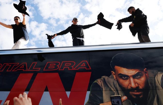 Die Rapper Lacazette, Capital Bra und Samra werfen bei einer Fanaktion in Kreuzberg T-Shirts von einem Tourbus.<span class='image-autor'>Carsten Koall/dpa</span>