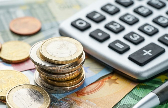 Geld und ein Taschenrechner liegen auf einem Tisch. (Symbolfoto)<span class='image-autor'>Foto: stock.adobe.com</span>