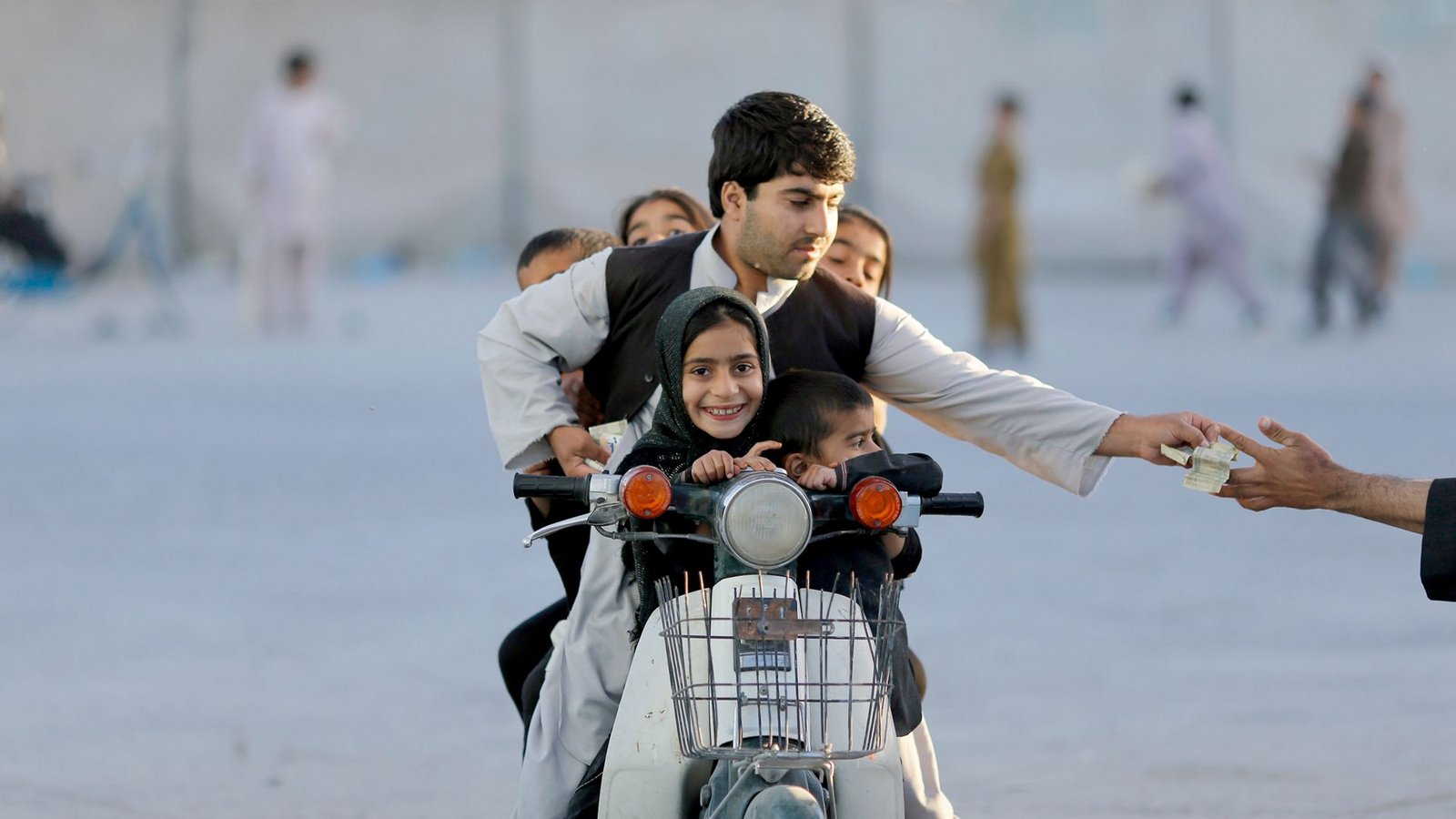 Kandahar, Afghanistan, 2013: Ein Vater bezahlt Eintritt für einen Vergnügungspark.Foto: SWR/Anja Niedringhaus/pa