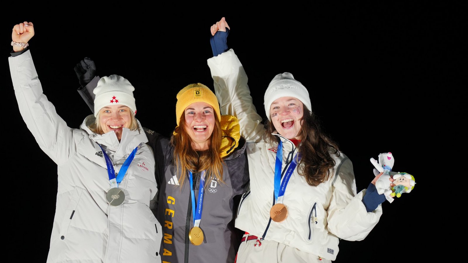 Die Rodlerinnen Elina Bota (Lettland, Silber, l-r), Julia Taubitz (Deutschland, Gold) und Ashley Farquharson (USA, Bronze) jubeln bei der Siegerehrung.Foto: picture alliance/dpa | Michael Kappeler
