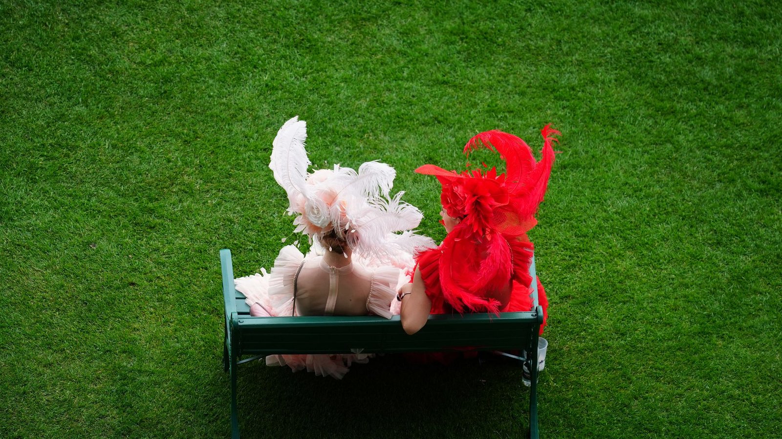 Rennbesucherinnen sitzen auf einer Bank am ersten Tag des Royal Ascot auf der Pferderennbahn von Ascot.Foto: David Davies/PA Wire/dpa