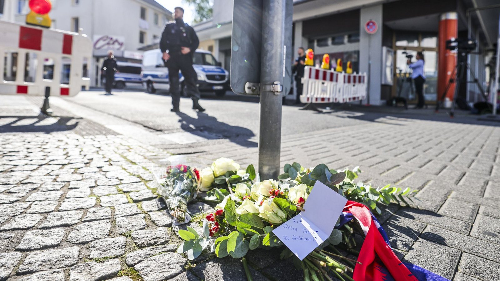 Nach der Messerattacke auf dem Solinger Stadtfest liegen in der Nähe des Tatorts Blumen auf einem Gehweg.Foto: dpa/Christoph Reichwein Nach der Messerattacke auf dem Solinger Stadtfest liegen in der Nähe des Tatorts Blumen auf einem Gehweg.Foto: dpa/Christoph Reichwein