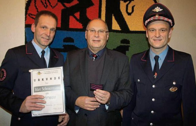 Kommandant Martin Schray (links) und Bürgermeister Werner Somlai befördern Marc Scheuermann zum Löschmeister. Foto: Jähne