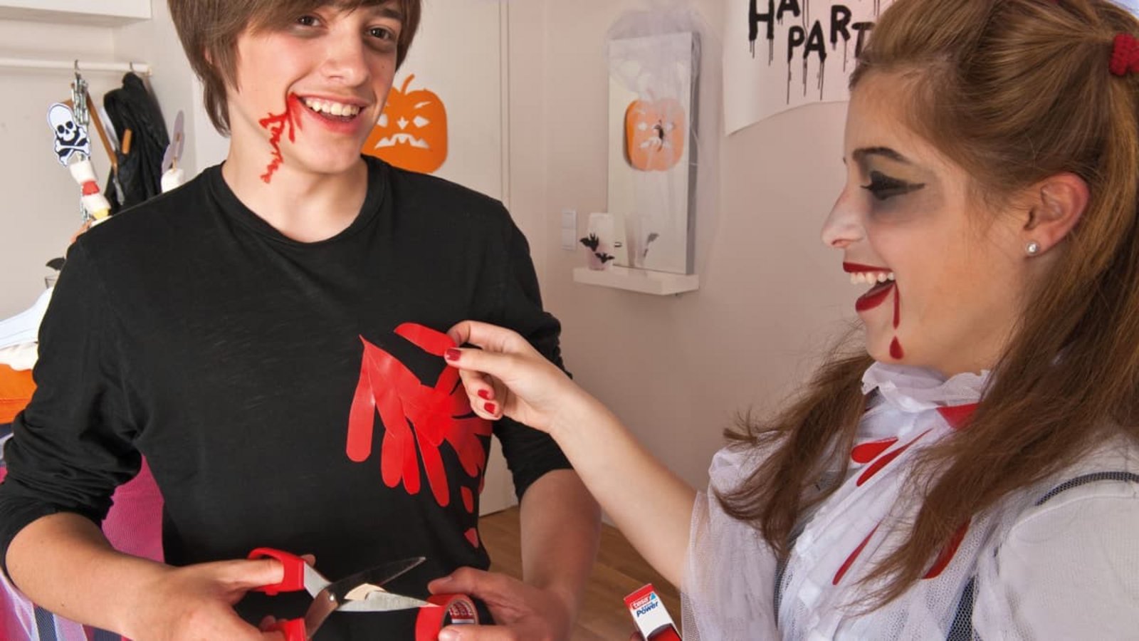 Zwei Kinder verkleiden sich für Halloween: Rotes Gewebeband imitiert Blut: Ausgeschnittene Tropfen und Streifen lassen sich auf ein ausgedientes schwarzes Shirt kleben.Tesa/DIY Academy/dpa-tmn/dpa Zwei Kinder verkleiden sich für Halloween: Rotes Gewebeband imitiert Blut: Ausgeschnittene Tropfen und Streifen lassen sich auf ein ausgedientes schwarzes Shirt kleben.Tesa/DIY Academy/dpa-tmn/dpa