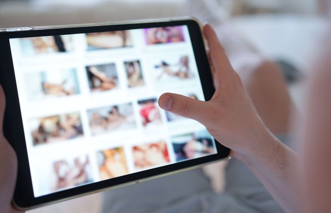 Ein junger Mann schaut sich auf einem Smartphone eine Porno-Internetseite an (gestellte Szene).<span class='image-autor'>Foto: Marcus Brandt/dpa</span>