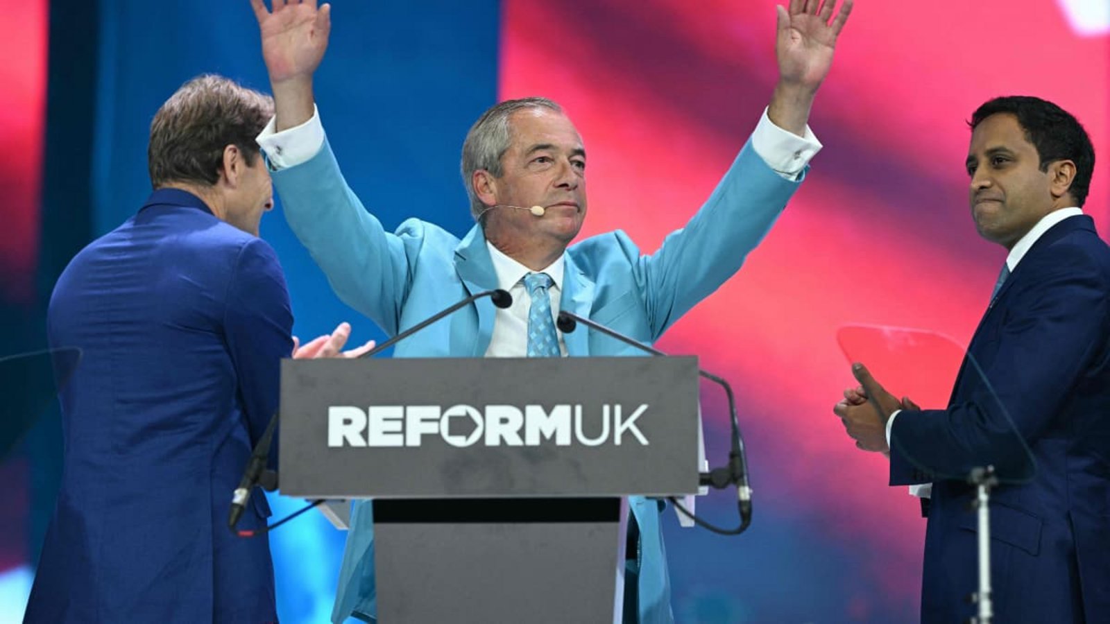 Der Chef der Reform UK Partei, Nigel Farage, wird nach seiner Rede auf dem Parteitag in Birmingham gefeiert. Auf der Bühne spenden ihm der stellvertretende Vorsitzende Richard Tice (L) und der Schatten-Innenminister Zia Yusuf Beifall.Oli Scarff/afp