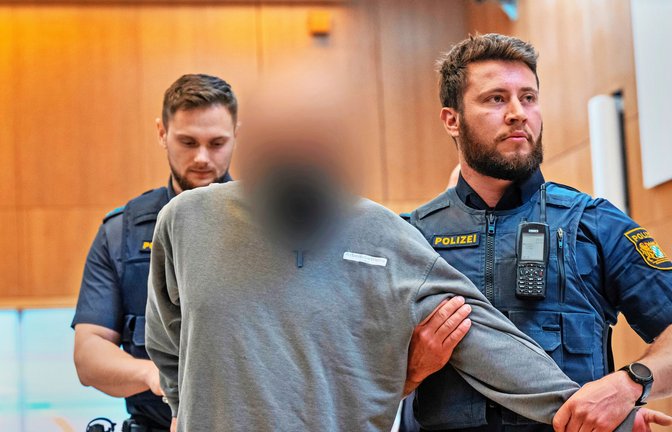 Einer der drei Angeklagten wird in München in den Gerichtssaal geführt. Es geht um schwer wiegende Vorwürfe.<span class='image-autor'>Foto: dpa/Peter Kneffel</span>