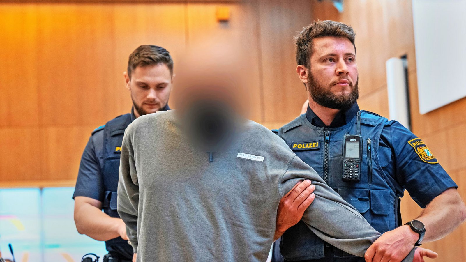 Einer der drei Angeklagten wird in München in den Gerichtssaal geführt. Es geht um schwer wiegende Vorwürfe.Foto: dpa/Peter Kneffel Einer der drei Angeklagten wird in München in den Gerichtssaal geführt. Es geht um schwer wiegende Vorwürfe.Foto: dpa/Peter Kneffel