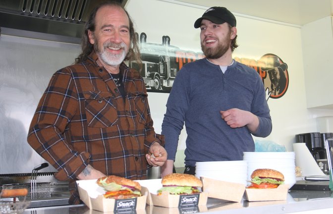 Ein gutes Gespann: Vater Mark Babbitt und Sohn Aiden mit drei Hamburgern, die ein Kunde mitnimmt.  <span class='image-autor'>Fotos: Rücker</span>