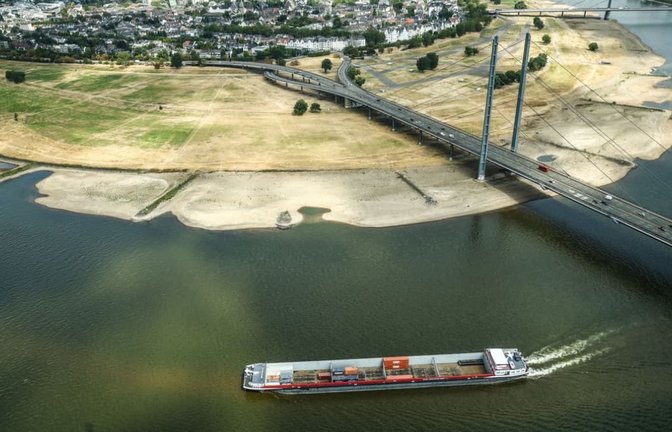 Ein Containerschiff fährt mit geringer Ladung bei Niedrigwasser am Rheinknie in der nordrhein-westfälischen Landeshauptstadt vorbei.<span class='image-autor'>Oliver Berg/dpa</span>