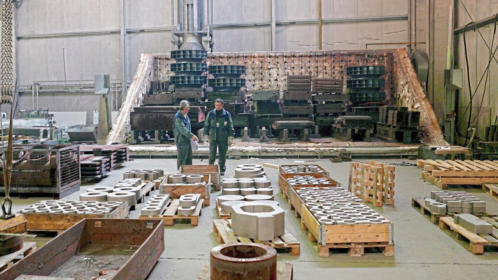 Im Hintergrund sieht man die untere Hälfte eines Glühofens. Durch Erwärmen und Abkühlen können die mechanischen Eigenschaften des Metalls oder der Metalllegierungen verändert werden.