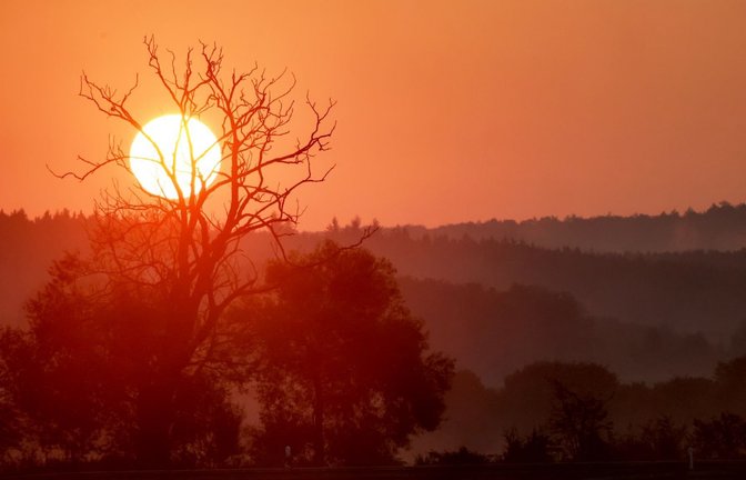 Die aufgehende Sonne färbt den Himmel am Morgen rot. (zu dpa: «Sommer kehrt zurück – Sonne vertreibt Gewitter im Südwesten»)<span class='image-autor'>Thomas Warnack/dpa</span>