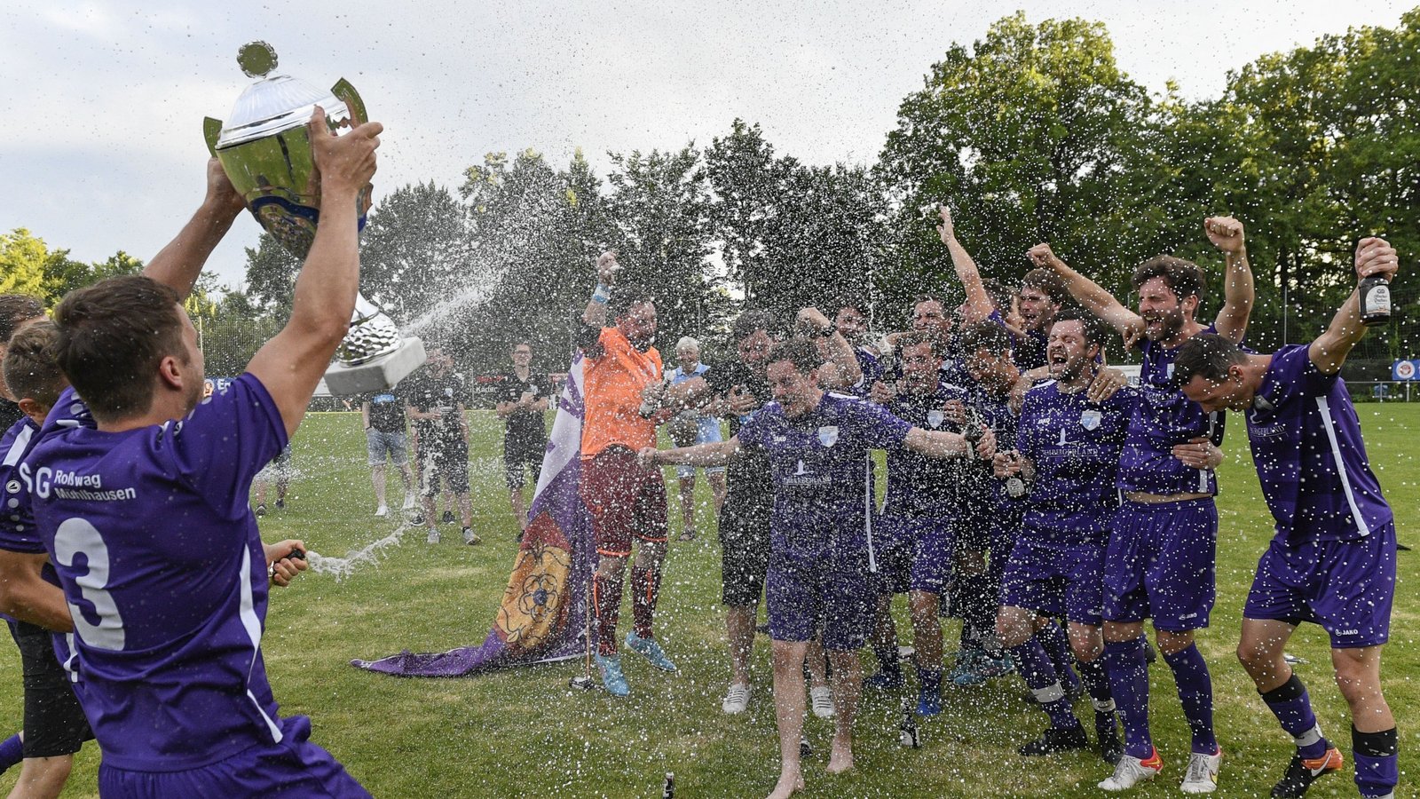 Mit einer Sektdusche feiern die Spieler der SGM Roßwag/Mühlhausen den Sieg beim Vaihinger Fußball-Stadtpokal in Ensingen. Fotos: Leitner