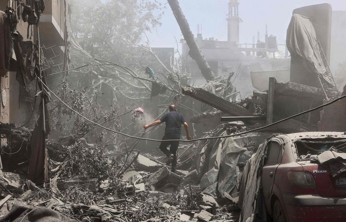 Ein Anwohner von Gaza-Stadt läuft durch die Trümmer.<span class='image-autor'>Foto: OMAR AL-QATTAA/AFP</span>