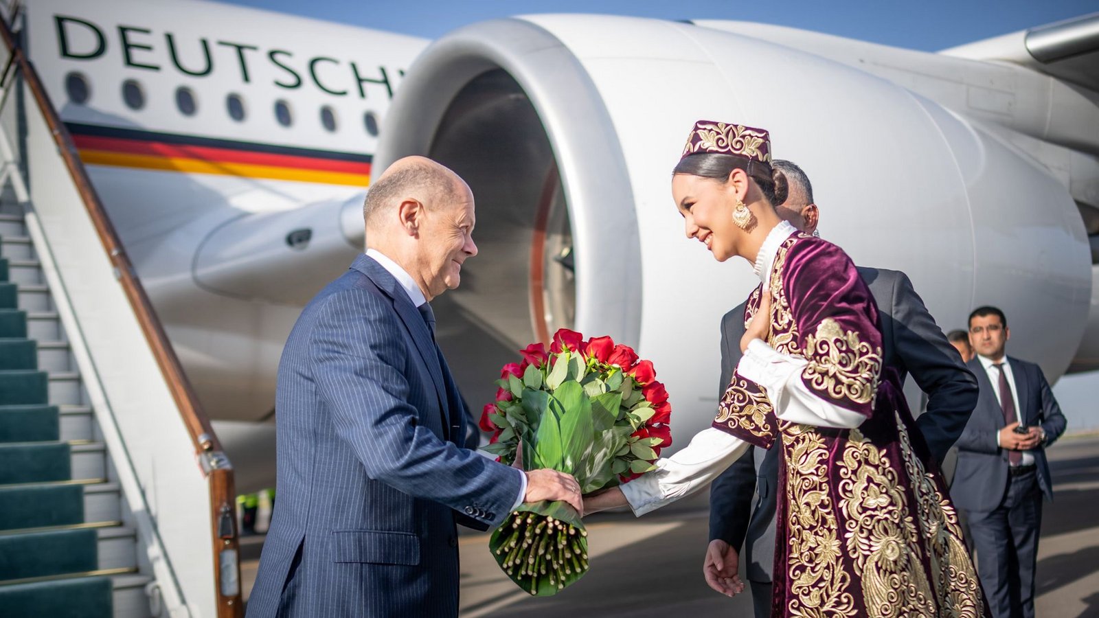 Bundeskanzler Olaf Scholz (SPD) wird am Flughafen von Samarkand begrüßt.Foto: dpa/Michael Kappeler