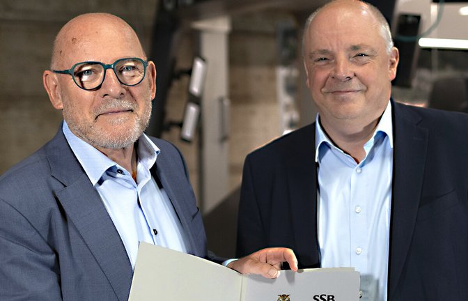 Schriftliche Zusage: Verkehrsminister Winfried Hermann (links) übergibt symbolisch die Fördermittel an SSB-Vorstand Thomas Moser.<span class='image-autor'>Foto: Lichtgut/Leif Piechowski</span>