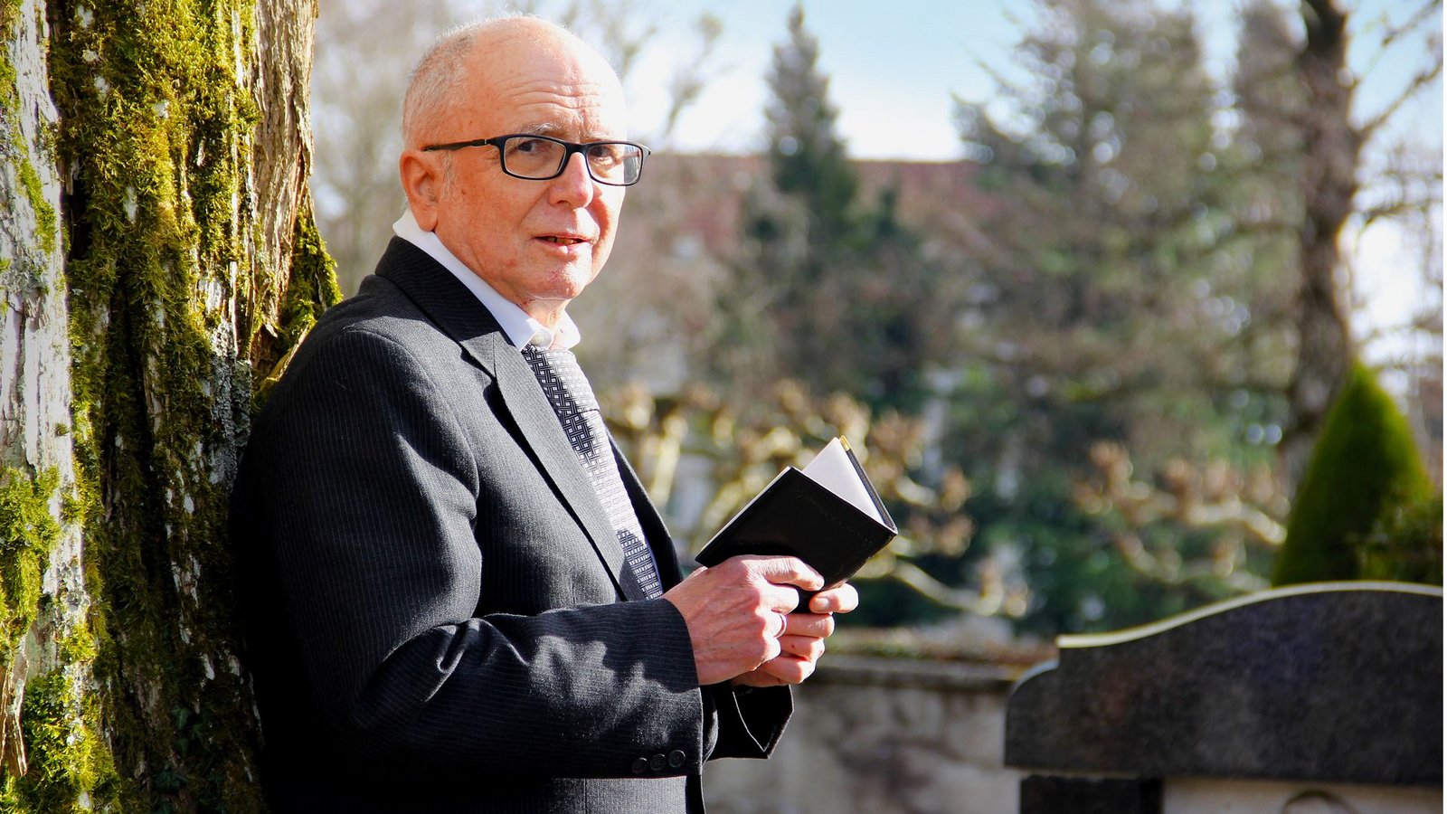 Nadelstreifenanzug, ein weißes Hemd und eine dezent gemusterte Krawatte – damit ist seine Berufskleidung perfekt: der Trauerredner Karlheinz Fahlbusch auf dem Friedhof von Meersburg.Foto: Uli Fricker
