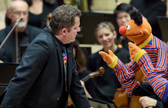 Dirigent David Claessen im Gespräch mit Ernie während des Familienkonzerts im Großen Saal der Elbphilharmonie.<span class='image-autor'>Foto: Georg Wendt/dpa</span>