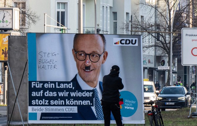 Mit Schmierereien verunziertes Wahlplakat von Friedrich Merz.<span class='image-autor'>Foto: AFP/JOHN MACDOUGALL</span>