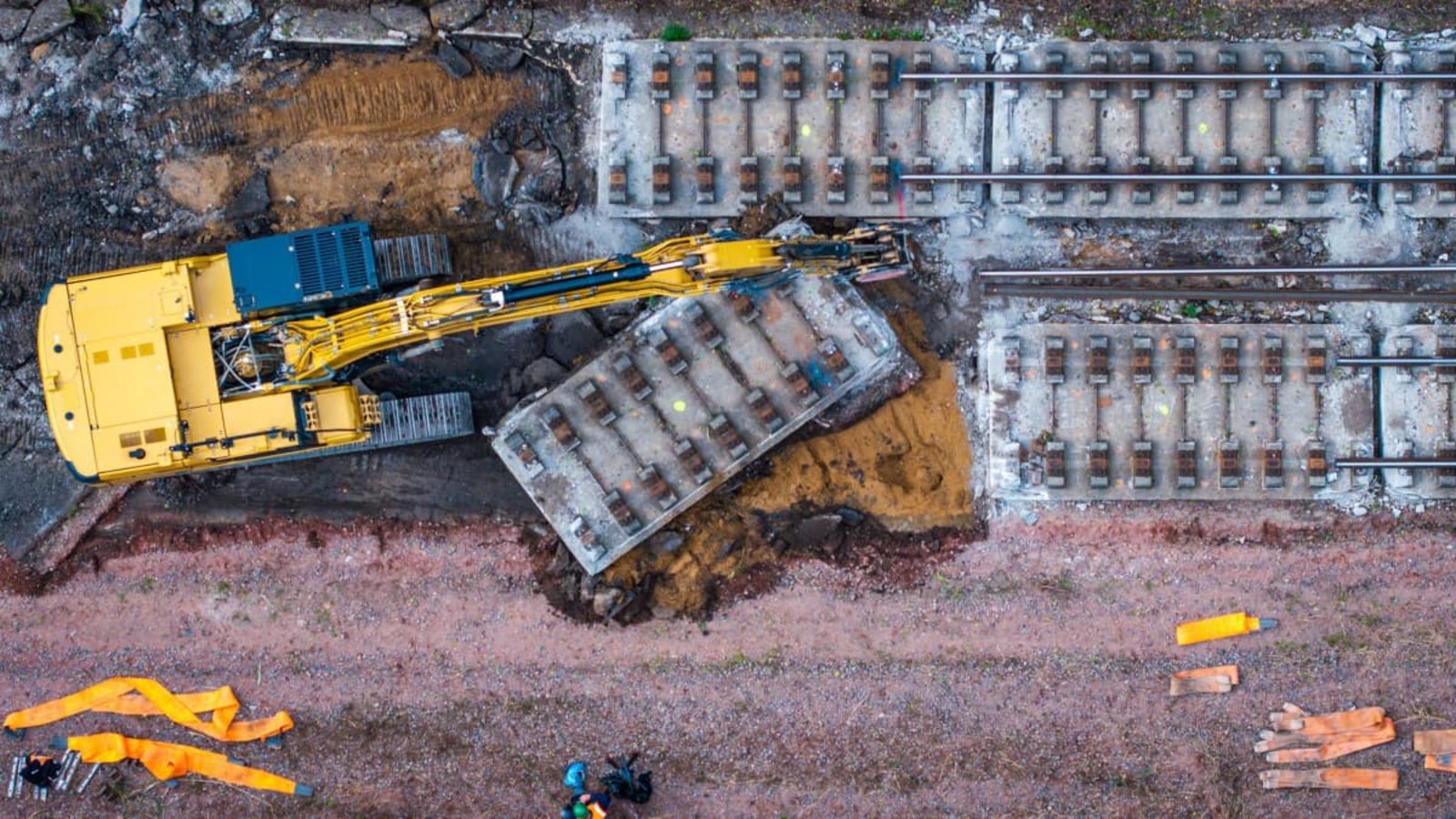 Mit schwerer Technik wird auf einem Teilstück der Bahnstrecke Hamburg-Berlin die vor Jahrzehnten eingebaute feste Fahrbahn aus Beton abgebaut. Dazu wird die Strecke in sechs Meter lange Platten zerschnitten und per Eisenbahndrehkran abtransportiert. Die Bauarbeiten sind Teil des neunmonatigen Sanierungsprojekts des Eisenbahn-Streckenabschnitts zwischen Berlin und Hamburg. (Luftaufnahme mit einer Drohne)Jens Büttner/dpa