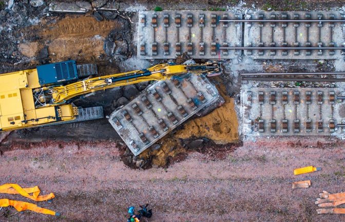 Mit schwerer Technik wird auf einem Teilstück der Bahnstrecke Hamburg-Berlin die vor Jahrzehnten eingebaute feste Fahrbahn aus Beton abgebaut. Dazu wird die Strecke in sechs Meter lange Platten zerschnitten und per Eisenbahndrehkran abtransportiert. Die Bauarbeiten sind Teil des neunmonatigen Sanierungsprojekts des Eisenbahn-Streckenabschnitts zwischen Berlin und Hamburg. (Luftaufnahme mit einer Drohne)<span class='image-autor'>Jens Büttner/dpa</span>