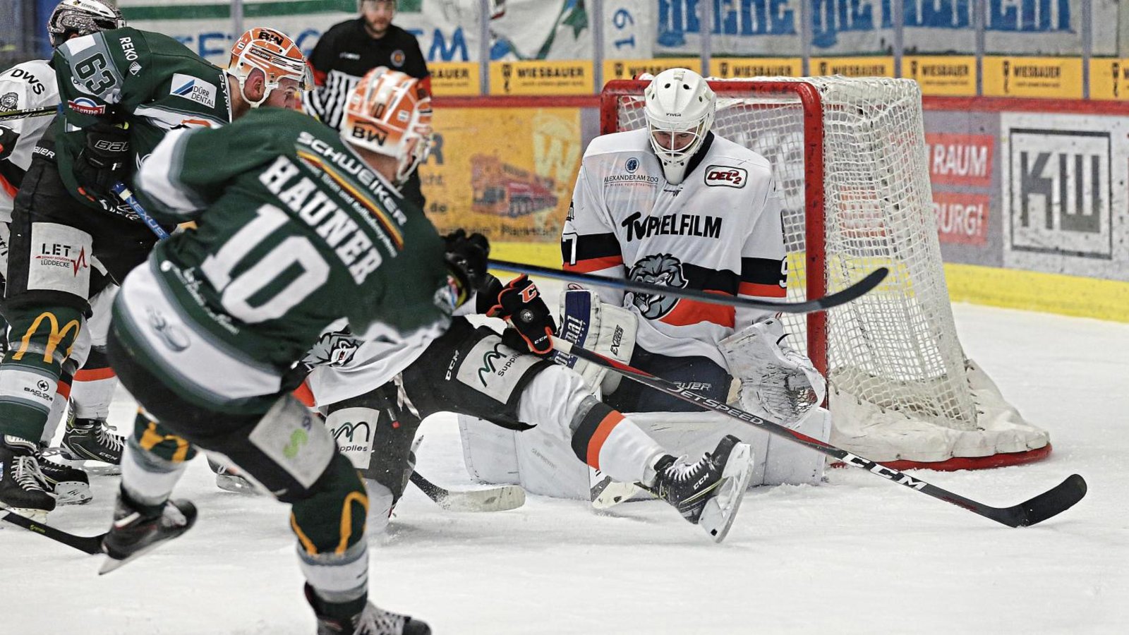 Wo ist der Puck? Nachdem Bietigheims Norman Hauner (vorne) abgezogen hat, setzt Shawn Weller (links) gegen Löwen-Goalie Ilya Andryukhov (rechts) nach. Foto: Baumann Wo ist der Puck? Nachdem Bietigheims Norman Hauner (vorne) abgezogen hat, setzt Shawn Weller (links) gegen Löwen-Goalie Ilya Andryukhov (rechts) nach. Foto: Baumann