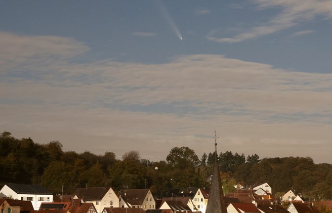 „Man muss schon genau hinschauen“, sagt Martin Litschel, der von seinem Balkon in Aurich den Kometen C/2023 A3 Tsuchinshan-Atlas mit bloßem Auge erspäht hat. Auf seiner acht Sekunden lang belichteten Aufnahme ist er aber zwischen den Wolken und über dem Turm der Kirche deutlich zu sehen.