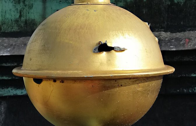 Bei der Sanierung entdeckt: Die goldene Kugel am Stadtkirchenturm weist Einschusslöcher auf.<span class='image-autor'>Foto: Eckart Schultz-Berg</span>