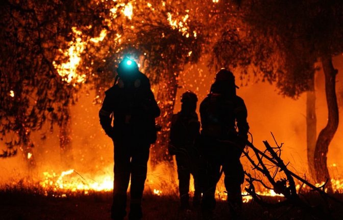 Feuerwehrleute löschen die Flammen während eines Waldbrandes in Asprochori, Oropos, Attika.<span class='image-autor'>Giorgos Arapekos/ZUMA Press Wire/dpa</span>