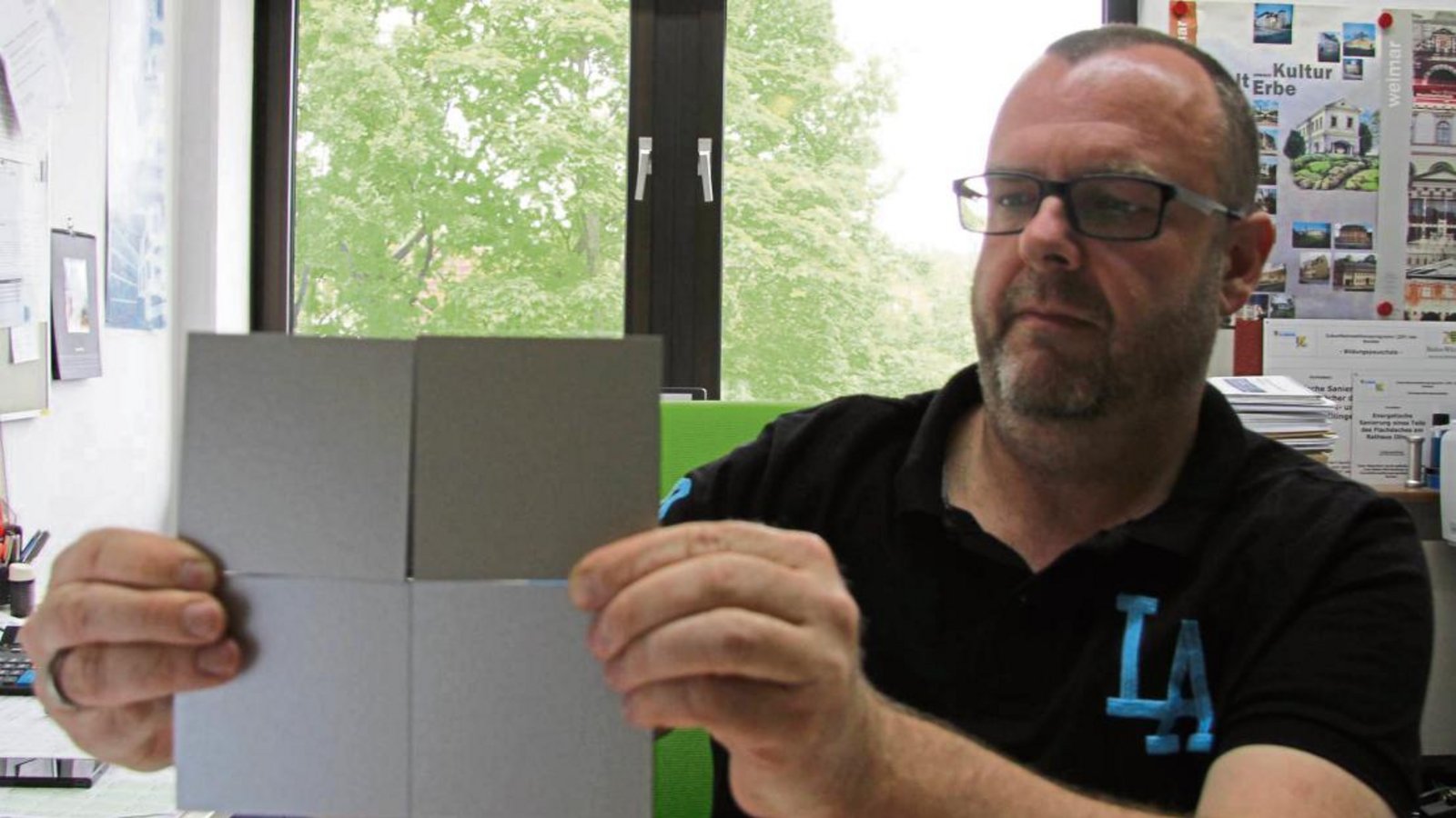 Ortsbaumeister Matthias Meinhardt zeigt Muster der Trespa-Platten, die für die neue Fassadenverkleidung infrage kommen.  Fotos: Banholzer